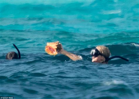 Jennifer Lawrence flaunts stunning bikini body as she swigs beer。